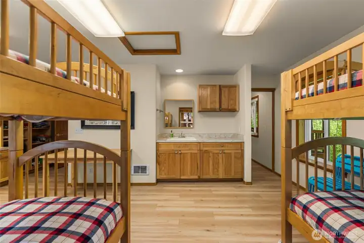 Bright and functional, the space features warm wood finishes, durable flooring, and a convenient vanity area with additional storage.