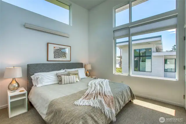 Upstairs in the primary suite, soaring vaulted ceilings are filled with morning and all day light.