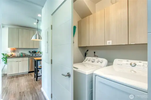 A full-sized washer and dryer are discreetly located at the base of the stairwell.