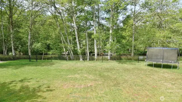 View of the backyard looking towards the Canal.  Yes, the trampoline stays.