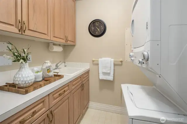 Utility room offers plenty of built-in storage and large capacity stacking washer & dryer