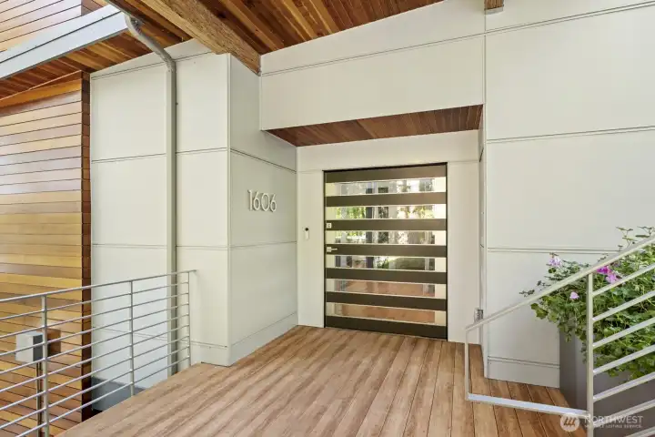 Striking contemporary entry sets the tone for this sophisticated lakefront retreat. Clean architectural lines and warm wood accents welcome you inside.