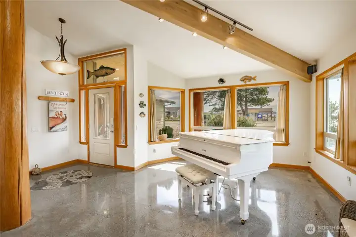 The grand piano exemplifies the wide open interior great room area which continues through living room, kitchen and Dining spaces.