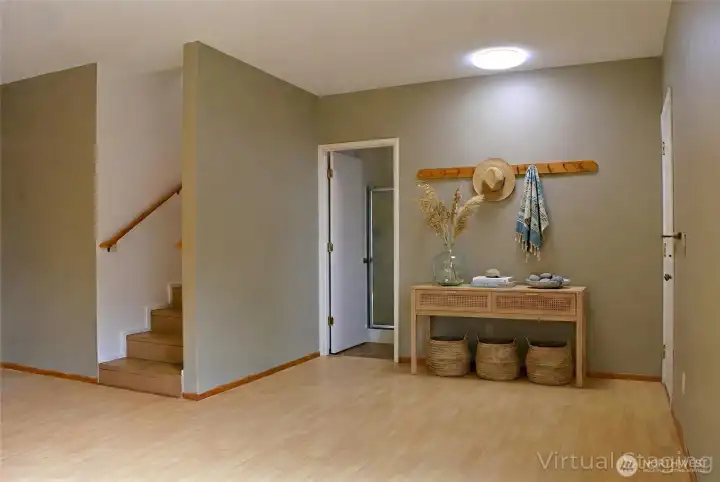The entryway is a bright, open space with light wood flooring and neutral walls.