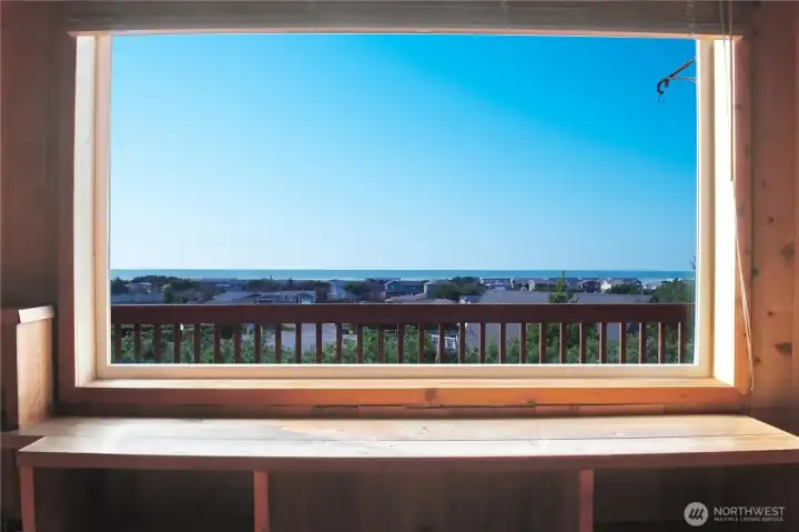 The upstairs living room showcases a stunning picture-frame ocean view that brings the coastline right into the home.