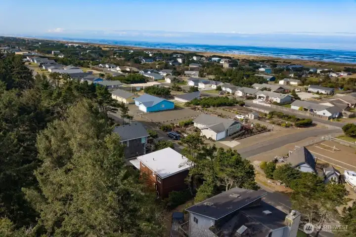 This aerial view highlights the home’s close proximity to the ocean, surrounded by a peaceful coastal neighborhood and natural dunes.