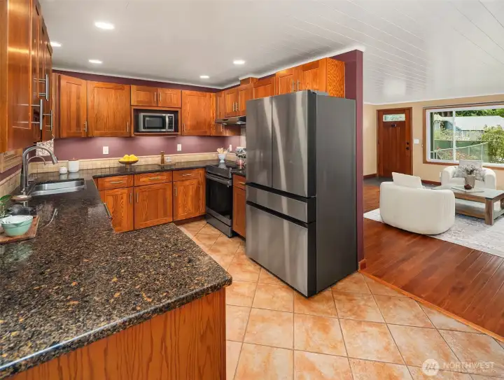 The kitchen boasts newer S/S appliances, granite countertops, and tile backsplash.