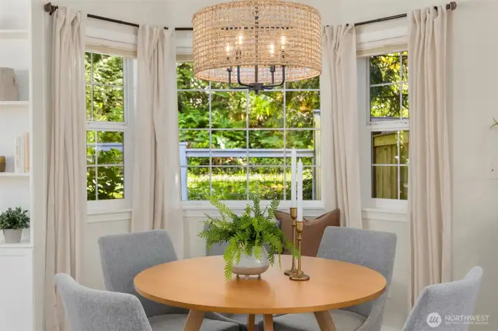 The dining area with a large bay window and updated lighting. The dining area with a large bay window and updated lighting.