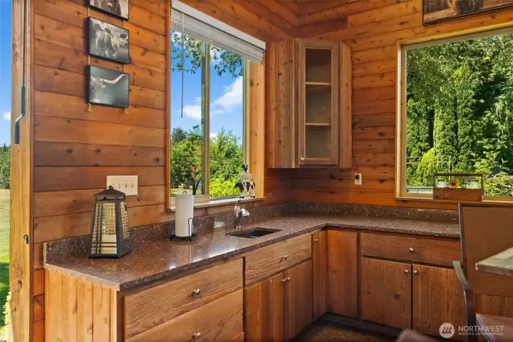 Outdoor kitchen has new granite countertops sink with hot and cold water and a full-size refrigerator not to mention apple storage