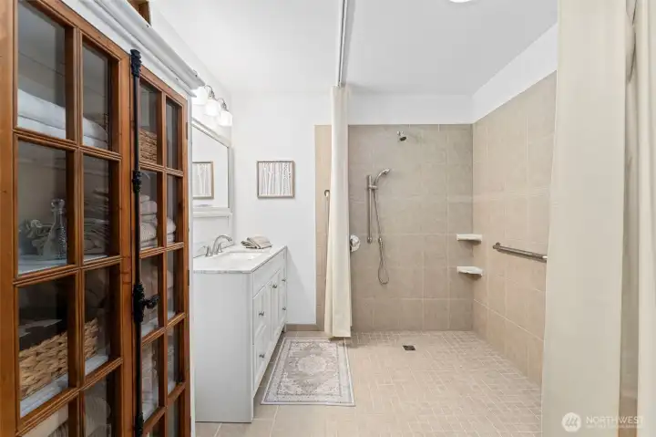 Roll in shower with track shower curtain-- ADA accessible.
