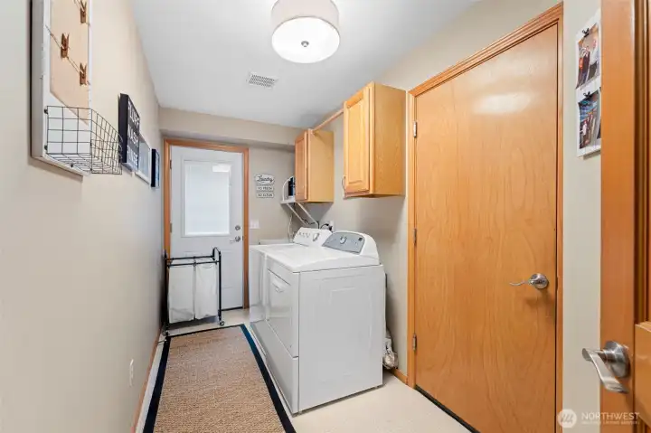 Functional utility room with cabinetry with garage entry & backyard access.