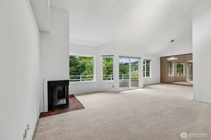 Fireplace-centered living room with balcony access and broad window wall.