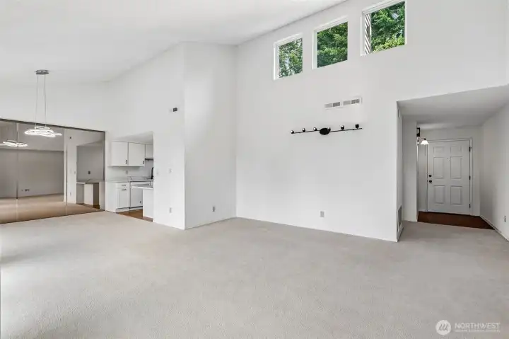 Spacious great room with entry, kitchen, and mirrored dining area.