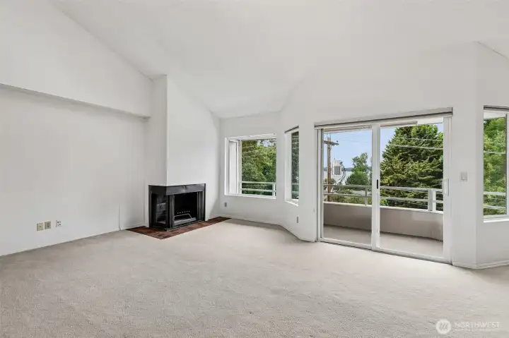 Open main living space with vaulted ceiling and kitchen connection.