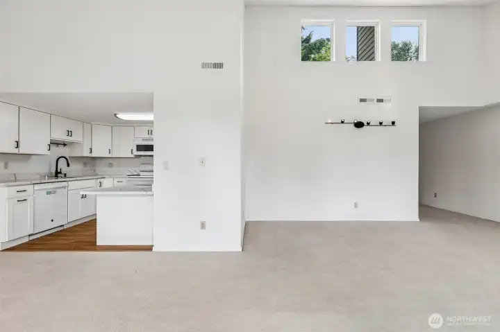 Open-concept main living area with vaulted ceilings and kitchen connection.