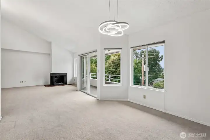 Dining area with fireplace, balcony access, and partial lake outlook.