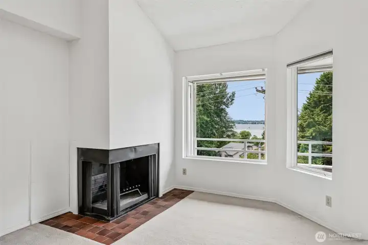 Living room fireplace with vaulted ceiling and lake-facing windows.