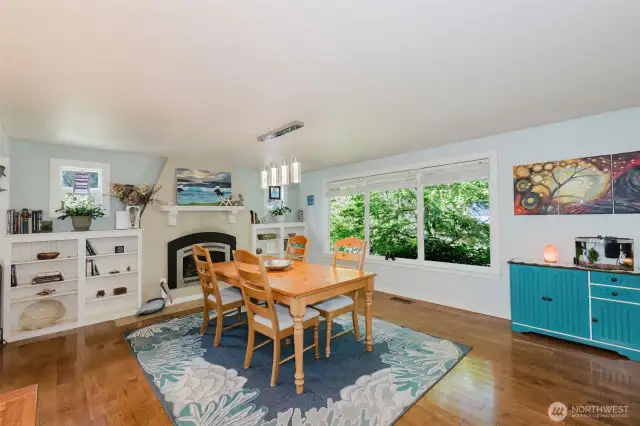 Dining area with propane fireplace, contemporary lighting, and West facing windows with natural surroundings make for a lovely dining experience.
