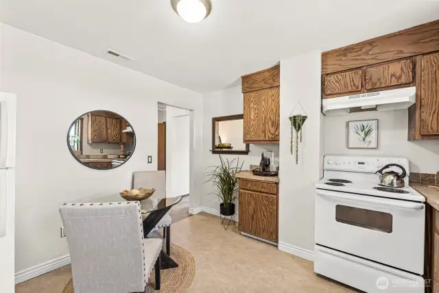 Crisp white appliances add a clean, classic look that complements the bright and airy feel of the eat-in area—perfect for enjoying morning coffee or casual meals.