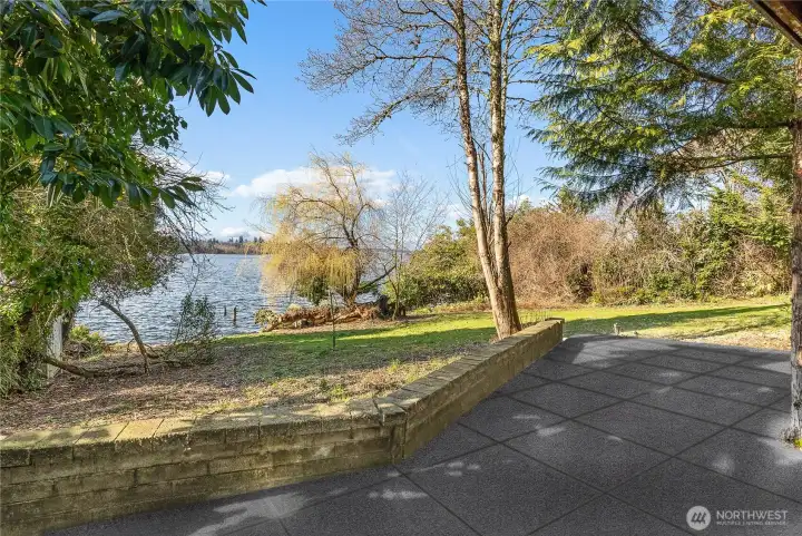 Lower-level patio with tranquil views across the lawn to the water’s edge.