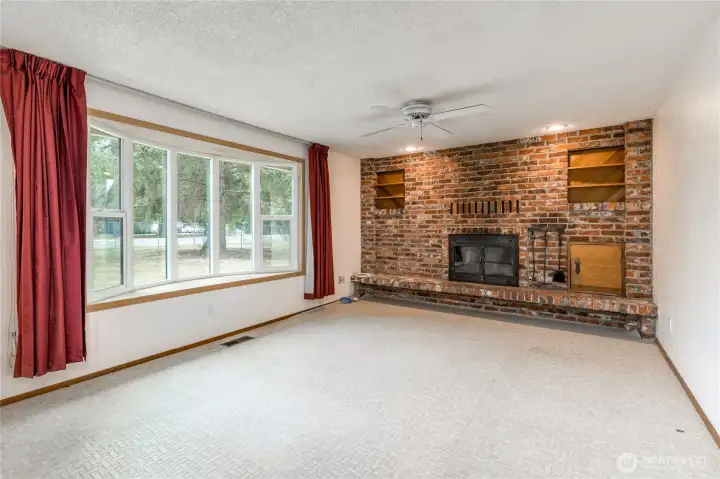 Family room features a brick fireplace surround with built-in shelving