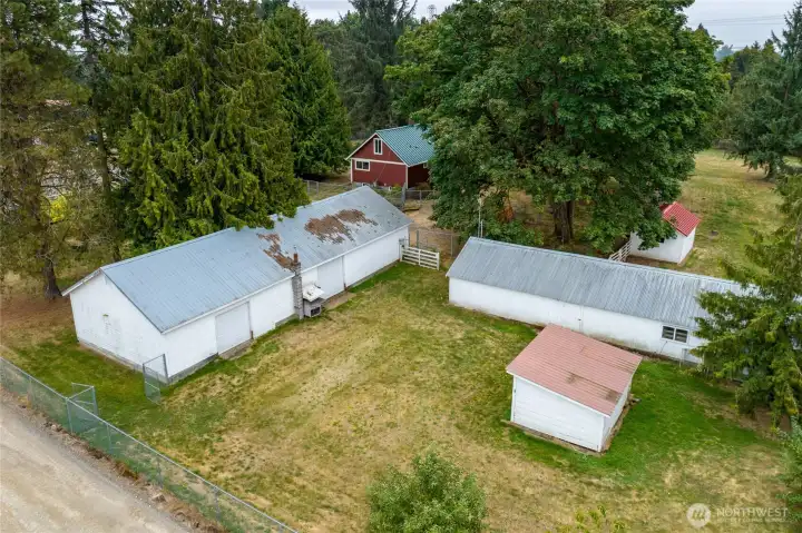Garage/shop, barn and chicken coop. Extensive cyclone fencing keeps different portions of the property separated.