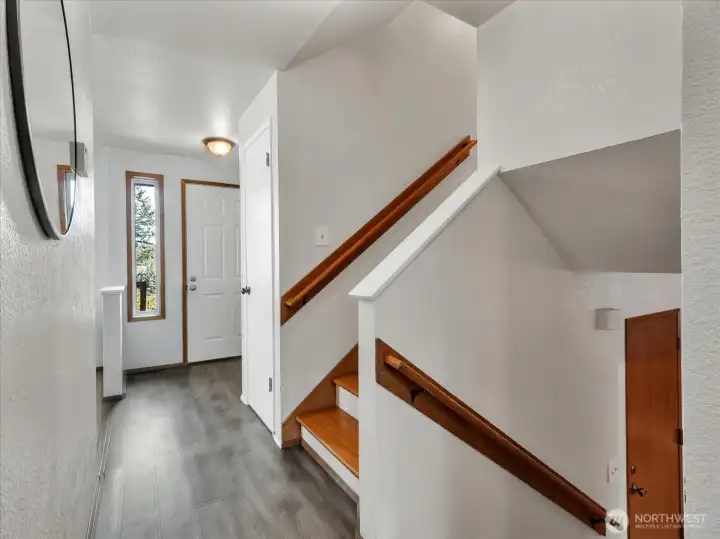 View to front door and stairs from kitchen