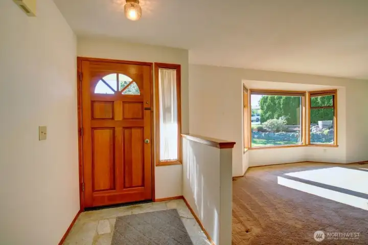 Front door and living room with bay windows