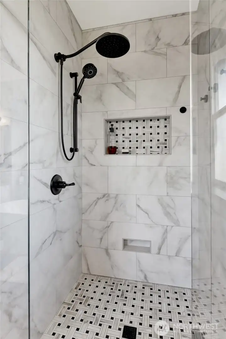 Rain shower and rain wand in this custom-tiled retreat invite luxurious, indulgent relaxation.