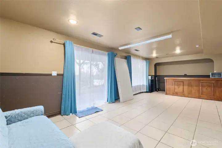 The spacious lower rec room offers versatile space for fun and entertaining, featuring a bar area and direct access to the lower patio for seamless indoor-outdoor living.