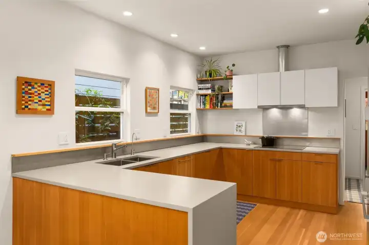 Designed with waterfall quartz countertops, a Fir paneled dishwasher and custom cabinetry to match.