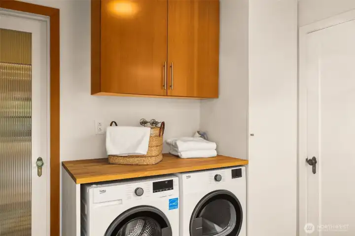 Laundry with custom shelving, new washer and dryer. The door leads to the half bath.