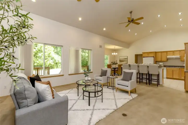 Living room with surround sound looking into bar seating area/kichen, outlets available on floor.