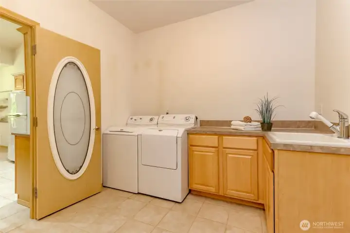 Large laundry room with pretty custom door, a sink and so much storage.