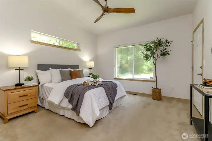 Primary bedroom with door that leads out to backyard deck. Great location to have morning coffee & see wildlife pass through in the morning.