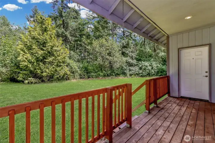 Backyard covered deck with doors from primary suite on one side and from the dining room on the other.