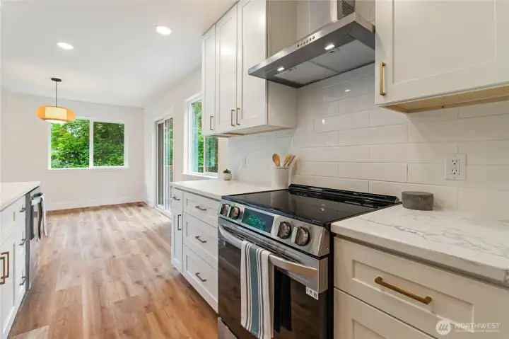 Slide in range with quartz counters and subway backsplash.