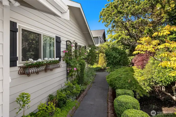 The approach to the home welcomes you through an enchanting garden on the street side of the home, originally designed by a previous owner who was a Master Gardener, creating a peaceful arrival filled with seasonal color and natural beauty. The approach to the home welcomes you through an enchanting garden on the street side of the home, originally designed by a previous owner who was a Master Gardener, creating a peaceful arrival filled with seasonal color and natural beauty.
