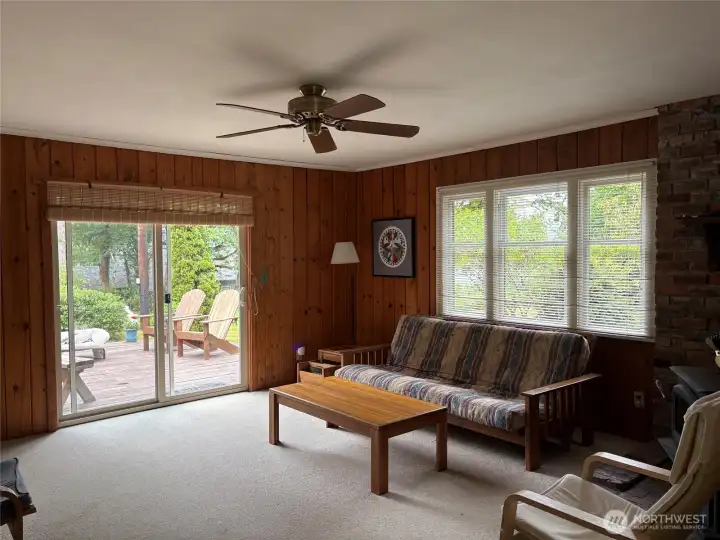 Main living room with slider to low profile wood deck providing great extension of the living area to the outdoors. Lots of natural light.