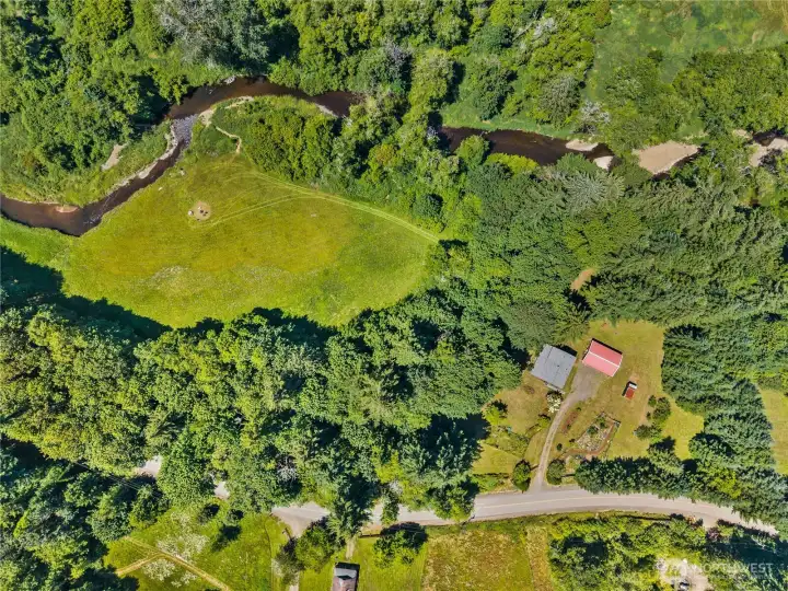 Upper part of the property has home, garage, trails with a hammock and vies of the creek. Lower part of the property features the creek, a large field, and backs up to capital forest.