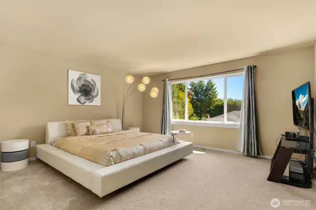 Luxurious primary bedroom with views of the backyard.