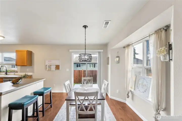 Dining area has plenty of space and leads to the backyard