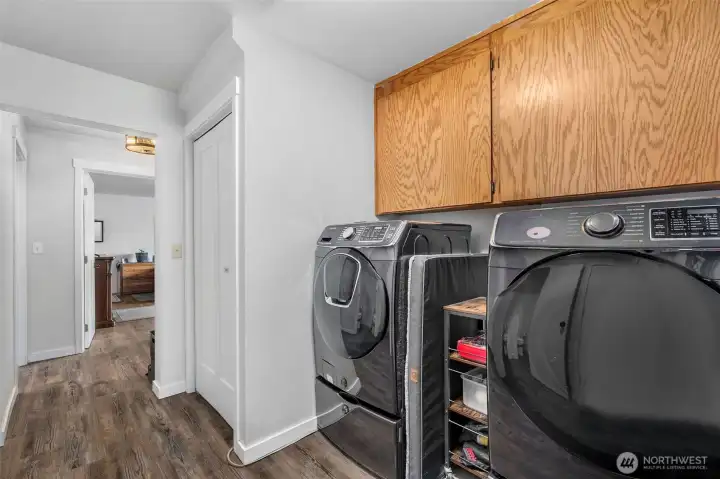 Hallway by kitchen. Home will come with all appliances including these front loading washer and dryer.
