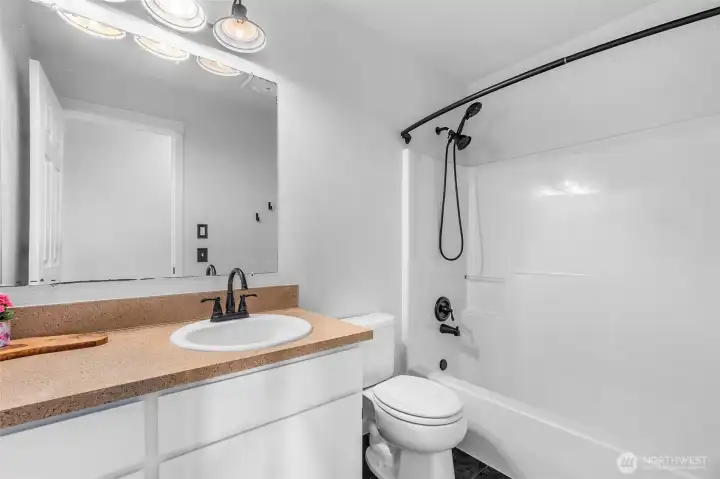 Hall bathroom upstairs with shower and tub. Updated fixtures and lighting.