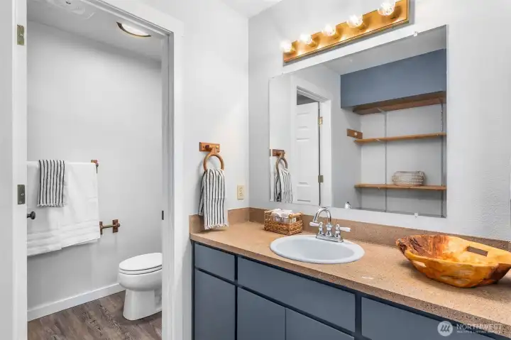 Adjoining bathroom for primary bedroom upstairs. Door closes for the toilet and shower area.