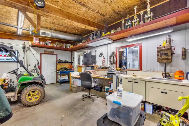 This is a view of the office area with built in desk. Has full sink/wash area. Small bathroom behind.