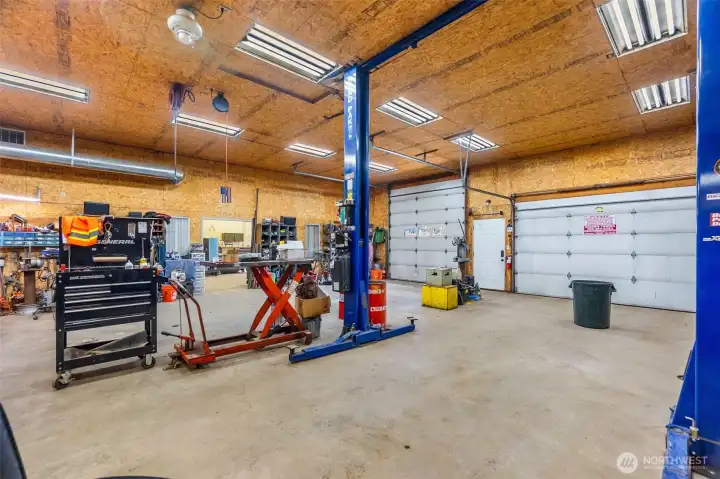 The shop- 200 amp main service. One 100 amp sub panel. Two 50 amp sub panels. Six 30 amp 220 plugs.12 foot eaves. Six inch concrete. Anchor points in slab. Six roll up doors. Four man doors. Ben pak 10,000 pound car/truck hoist.4 ton HVAC unit with spiral ductwork.Bathroom.Utility sink. Hot water.Small refrigerator.Office area.Fiberhigh speed internet. 4 power cord rells. One airhose reel. RV power plug. 110 plugs everywhere. Large attic space with plywood floor and an alarm system!