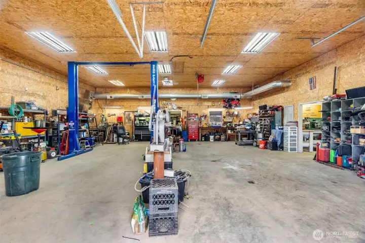 The shop- 200 amp main service. One 100 amp sub panel. Two 50 amp sub panels. Six 30 amp 220 plugs.12 foot eaves. Six inch concrete. Anchor points in slab. Six roll up doors. Four man doors. Ben pak 10,000 pound car/truck hoist.4 ton HVAC unit with spiral ductwork.Bathroom.Utility sink. Hot water.Small refrigerator.Office area. Fiber high speed internet. 4 power cord reels. One air hose reel. RV power plug. 110 plugs everywhere. Large attic space with plywood floor and an alarm system!