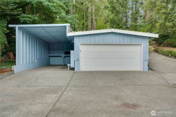 Large carport with an additional detached two-car garage offers flexibility and convenience
