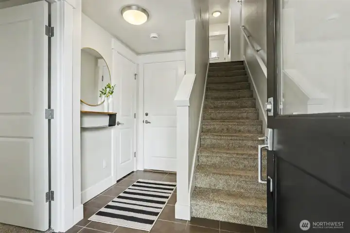 The entry with a bedroom or office to the left, door to the garage and stairs to the living area.